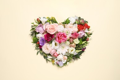 Photo of Beautiful heart made of different flowers on beige background, top view