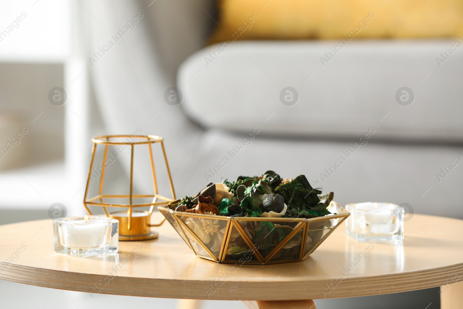 Photo of Aromatic potpourri of dried flowers in bowl on wooden table indoors