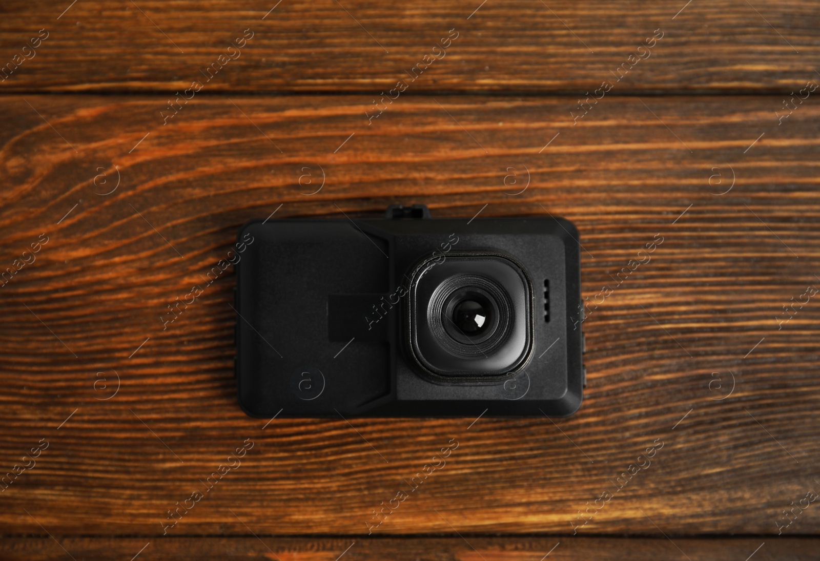 Photo of Modern car dashboard camera on wooden background, top view