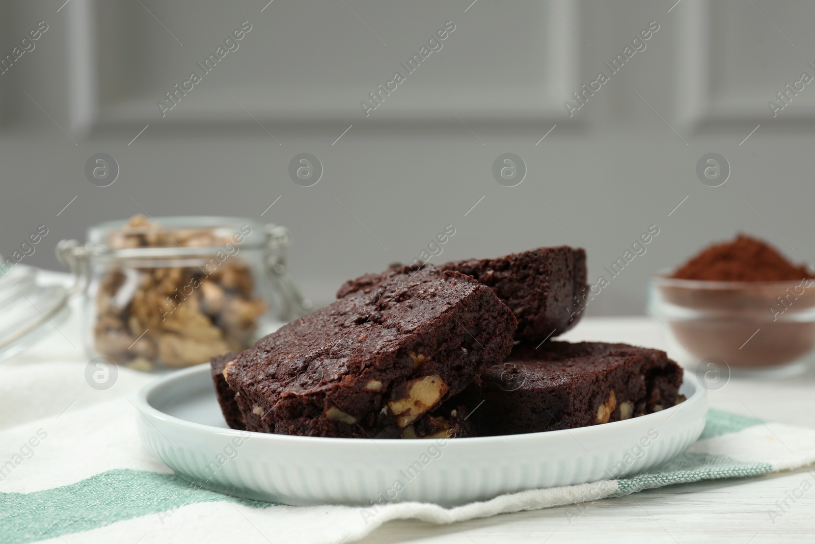 Photo of Delicious chocolate brownies with nuts on white table