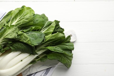 Photo of Fresh green pak choy cabbages on white wooden table, top view. Space for text
