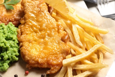 Photo of British traditional fish and potato chips on table, closeup