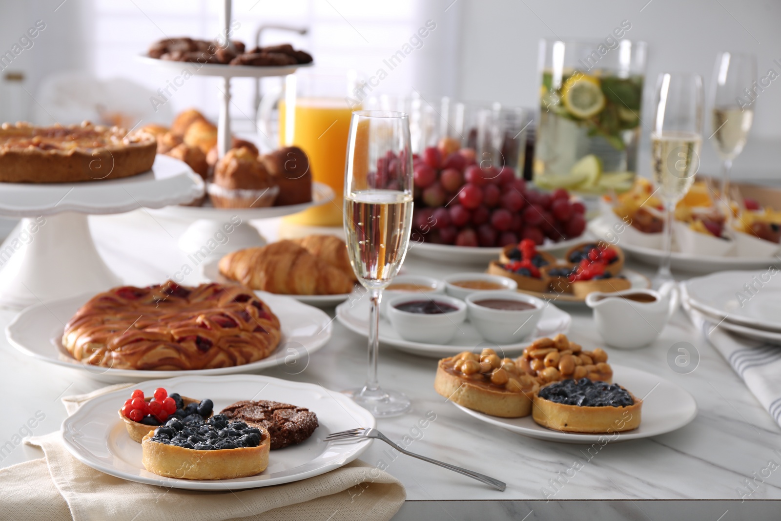 Photo of Variety of snacks on white marble table in buffet style indoors