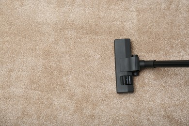 Photo of Removing dirt from carpet with vacuum cleaner indoors, top view. Space for text