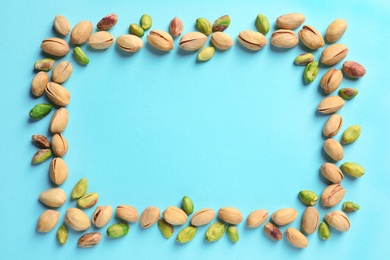 Photo of Frame made of organic pistachio nuts, flat lay. Space for text