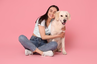 Photo of Happy woman with cute Labrador Retriever dog on pink background. Adorable pet