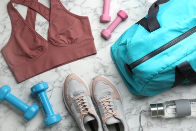 Photo of Flat lay composition with gym bag and sportswear on white marble table