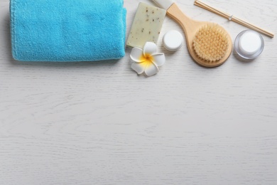 Photo of Flat lay composition with spa cosmetics and towel on wooden background