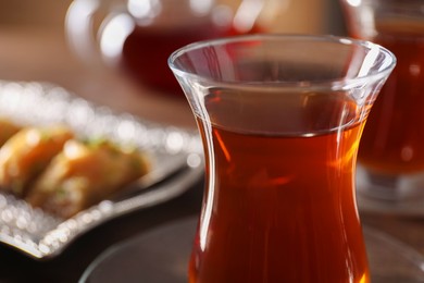 Traditional Turkish tea in glass on table, closeup. Space for text