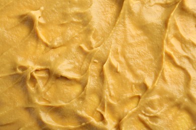 Photo of Fresh tasty mustard sauce as background, top view