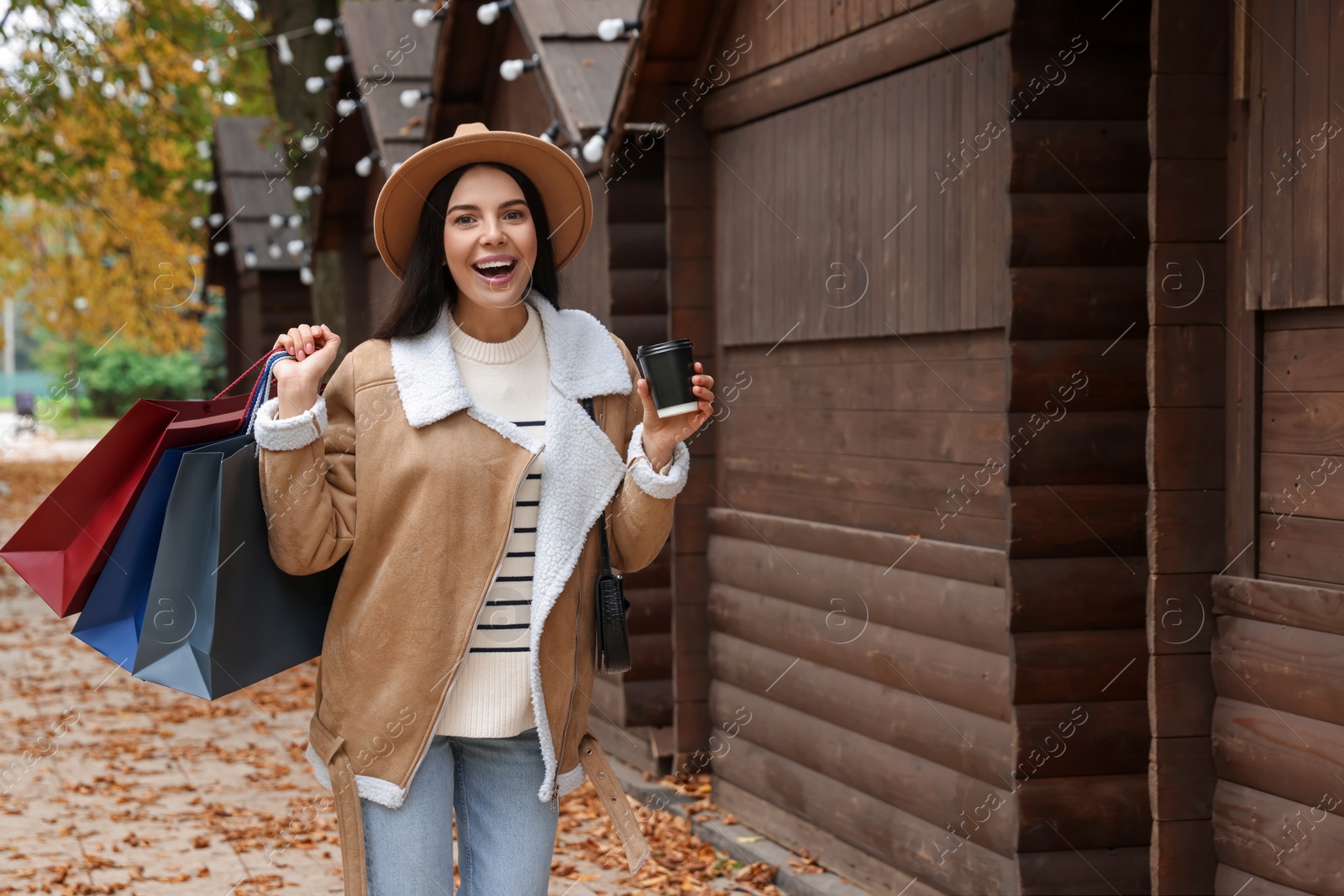 Photo of Special Promotion. Emotional young woman with shopping bags and cup of drink on city street