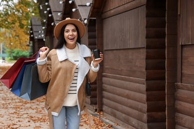 Photo of Special Promotion. Emotional young woman with shopping bags and cup of drink on city street