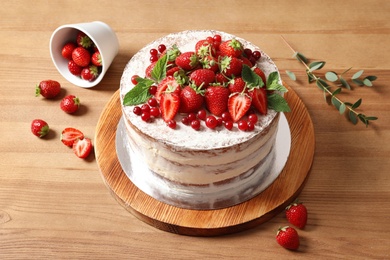 Delicious homemade cake with fresh berries on wooden table