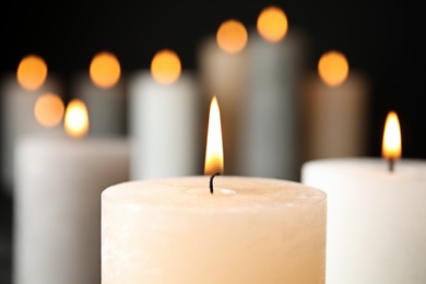 Photo of Alight wax candle on blurred background, closeup