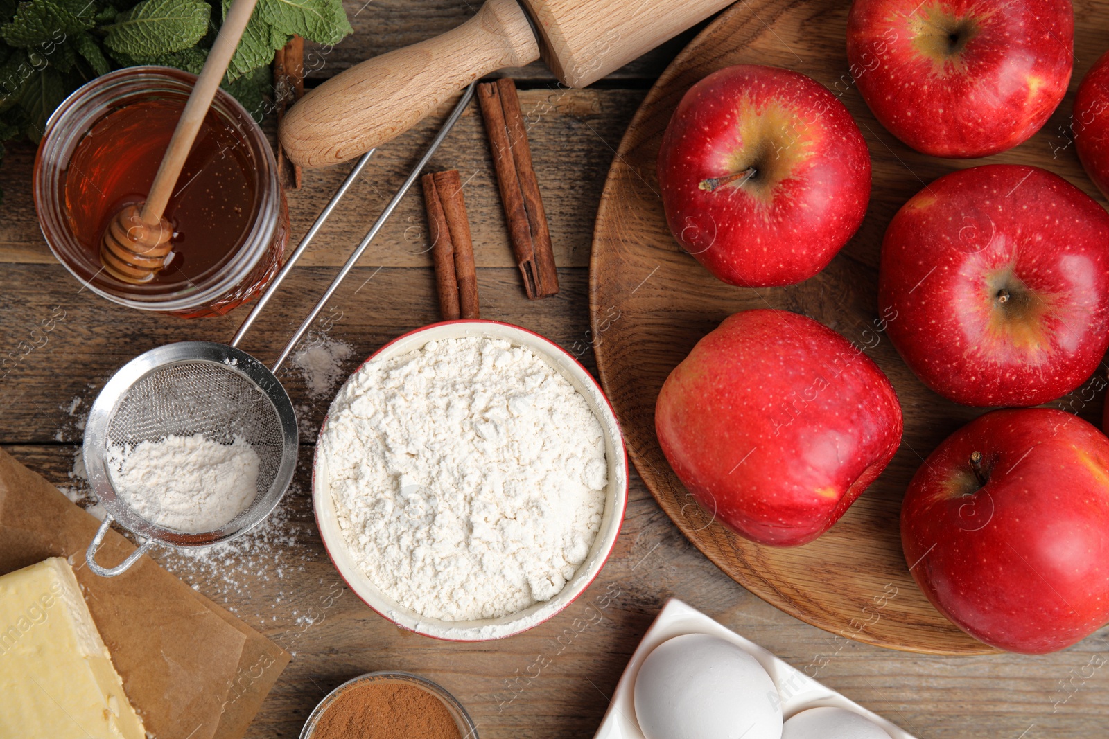 Photo of Traditional English apple pie ingredients on wooden table, flat lay