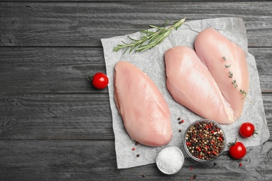 Flat lay composition with fresh chicken meat on black wooden table