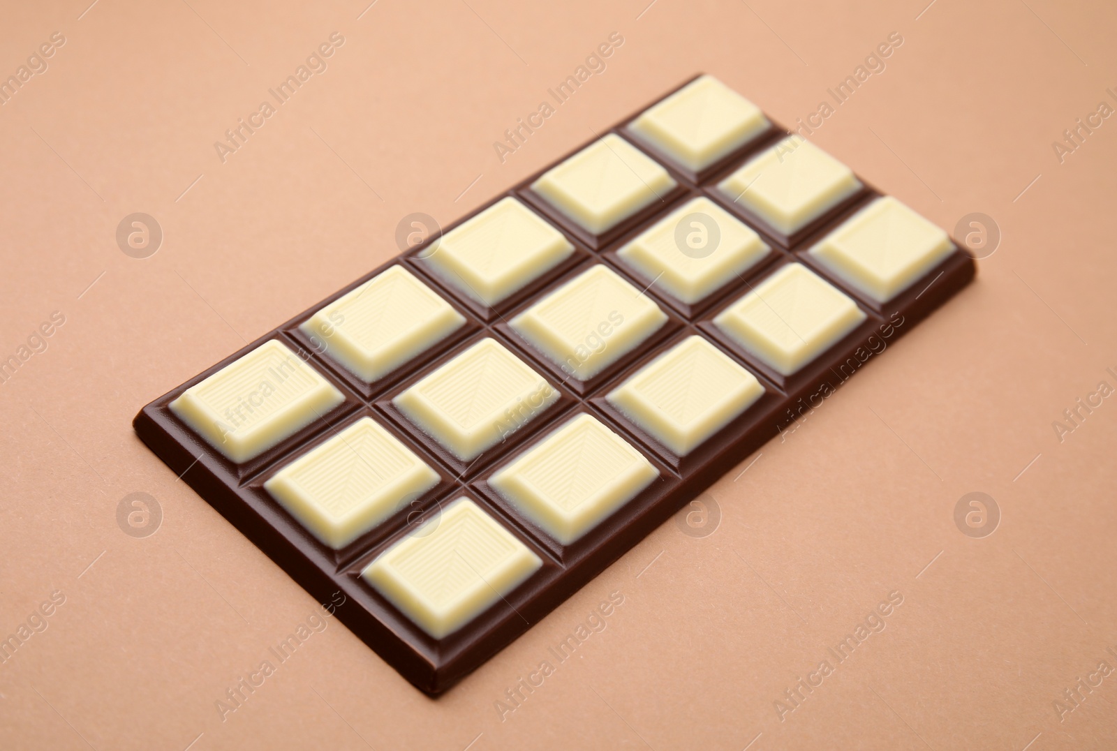 Photo of One tasty chocolate bar on brown background