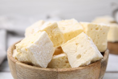 Bowl with tasty marshmallows on white table, closeup