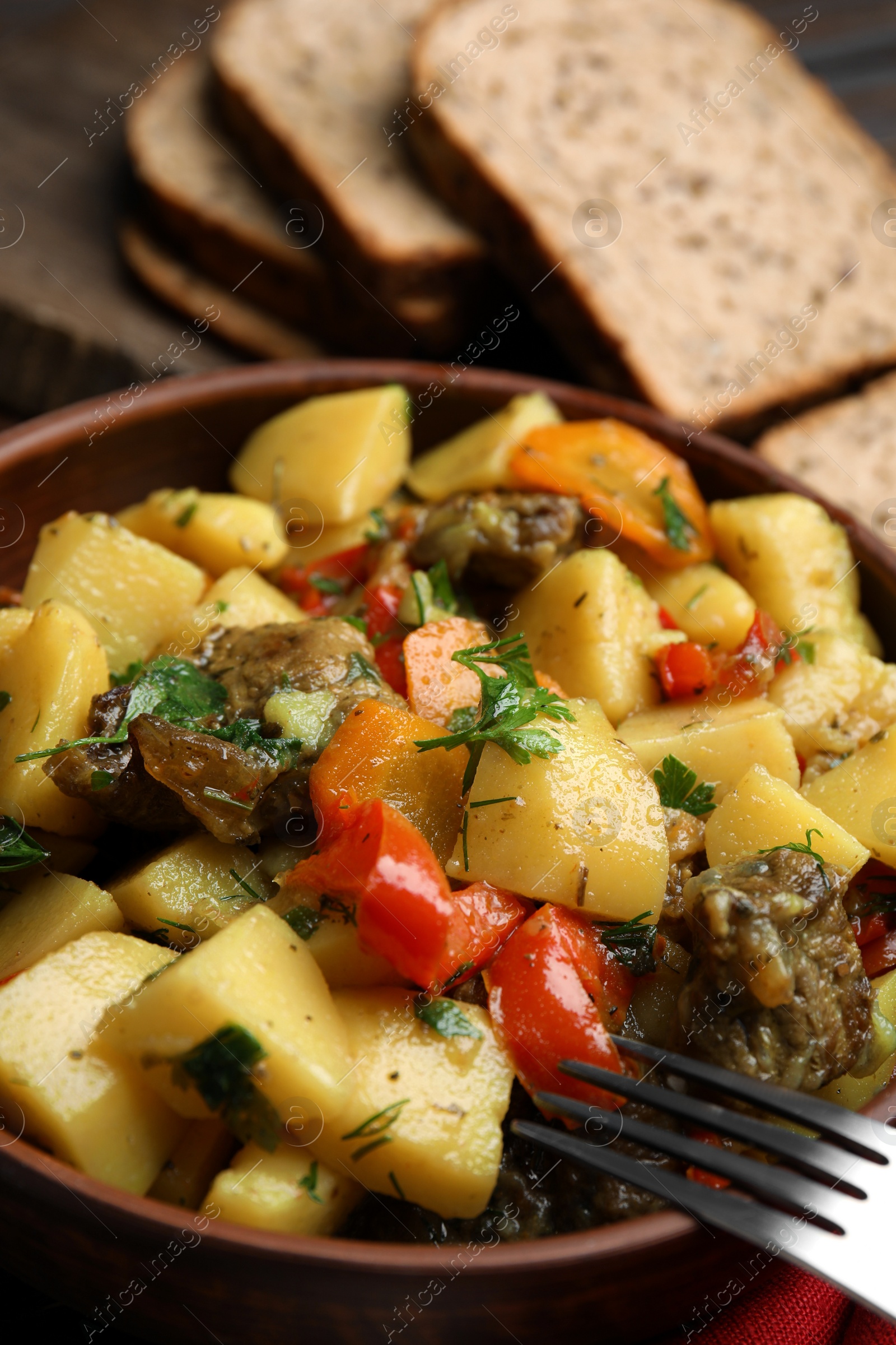 Photo of Tasty cooked dish with potatoes in earthenware, closeup