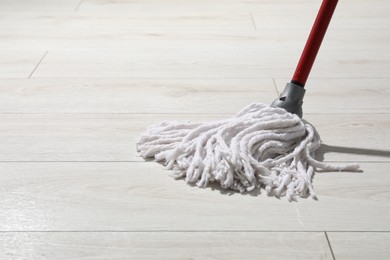 Cleaning white parquet floor with mop, closeup. Space for text