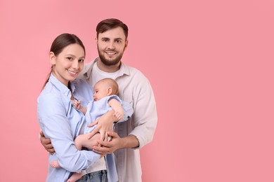 Photo of Happy family. Parents with their cute baby on pink background, space for text