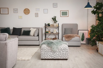 Photo of Modern living room interior with comfortable sofa and ottoman