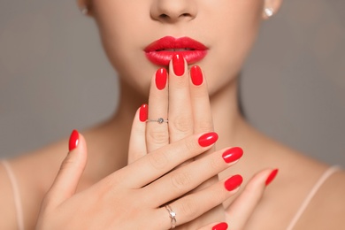 Beautiful young woman with bright manicure on color background, closeup. Nail polish trends