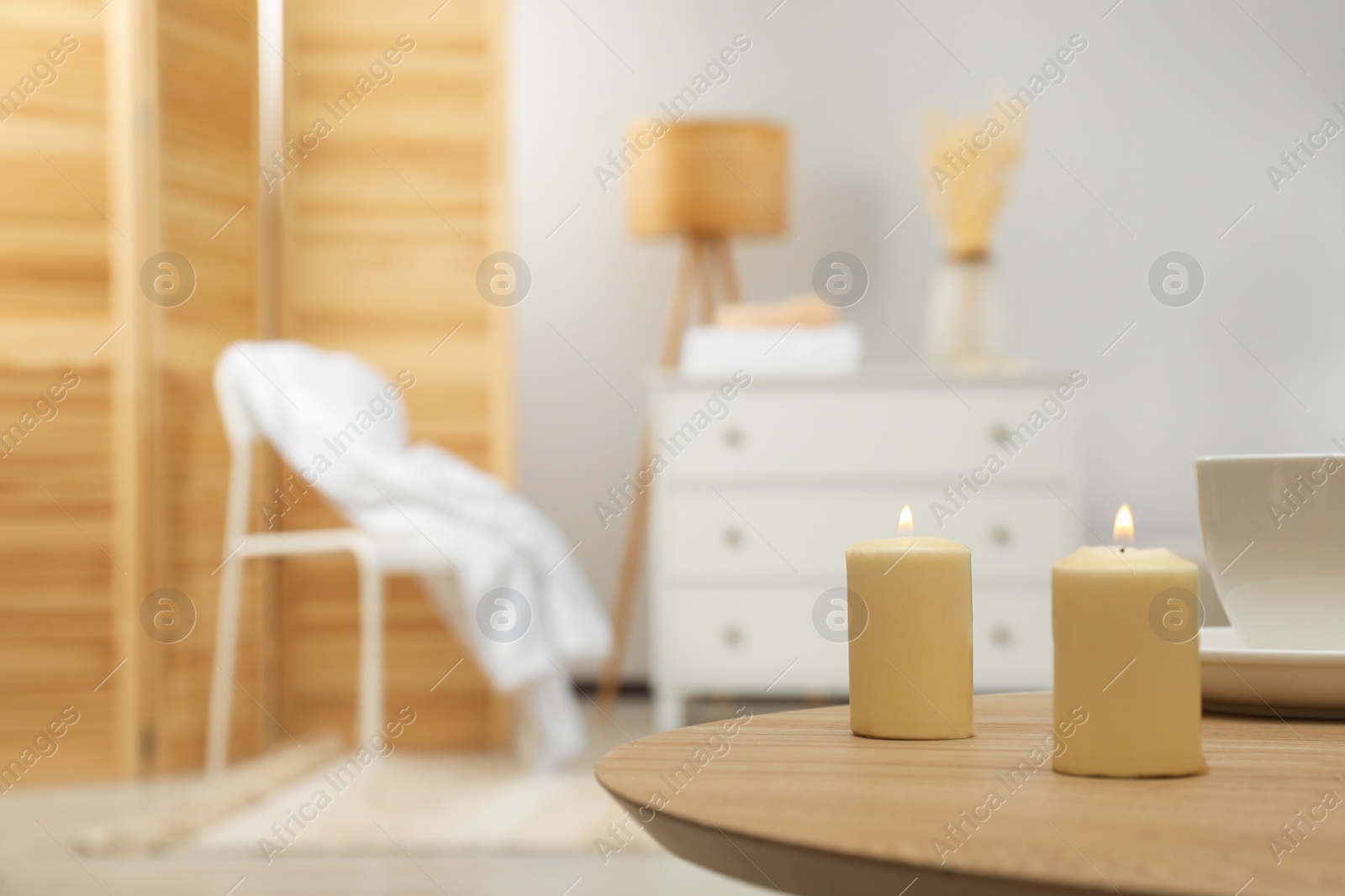 Photo of Wooden table with candles and cup, space for text. Interior design