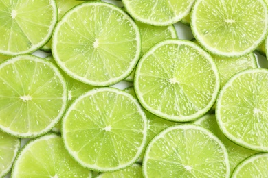 Fresh sliced ripe limes as background, top view