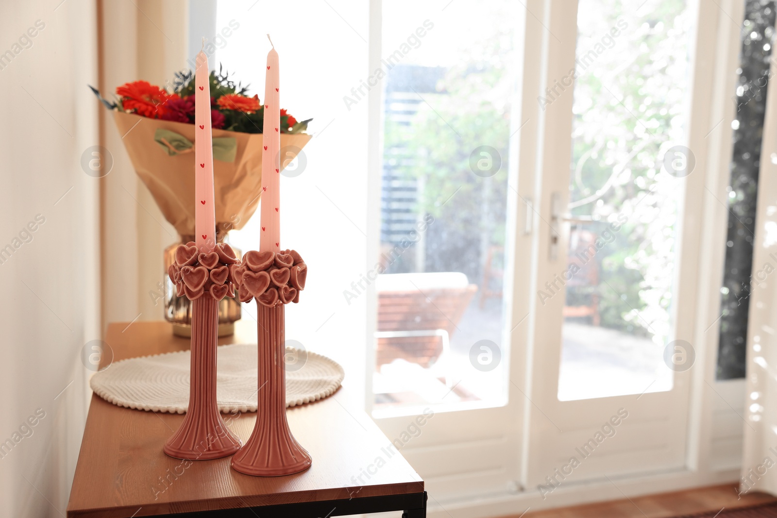 Photo of Bouquet of flowers and candles on wooden table indoors. Space for text