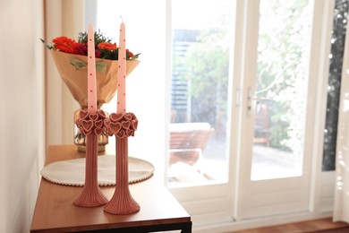 Photo of Bouquet of flowers and candles on wooden table indoors. Space for text