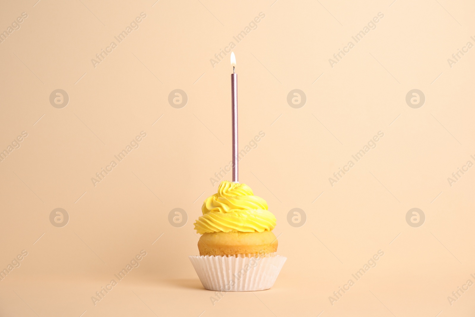 Photo of Birthday cupcake with candle on beige background