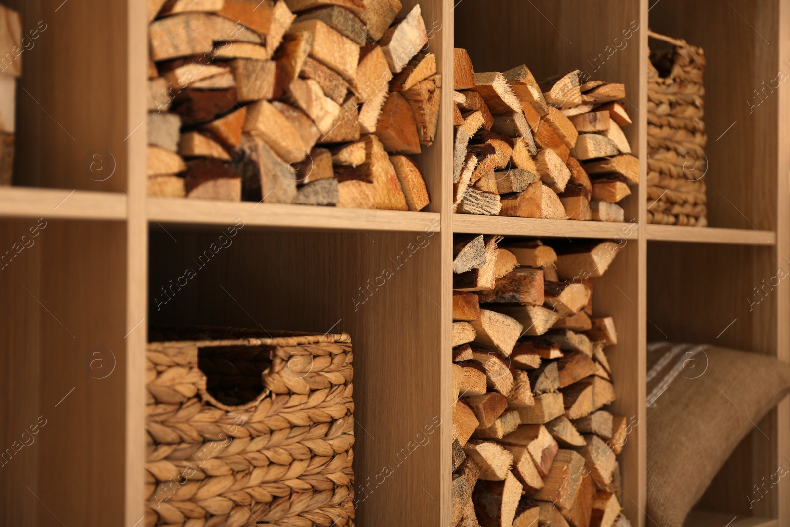 Photo of Shelving unit with stacked firewood, closeup. Idea for interior design