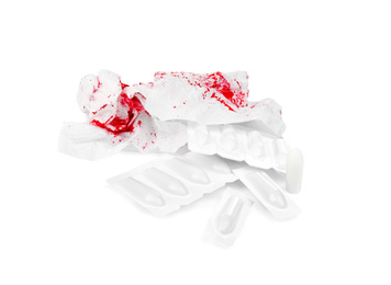 Photo of Sheets of toilet paper with blood and suppositories on white background. Hemorrhoid problems