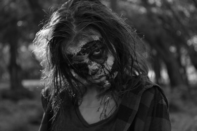 Scary zombie outdoors, black and white effect. Halloween monster