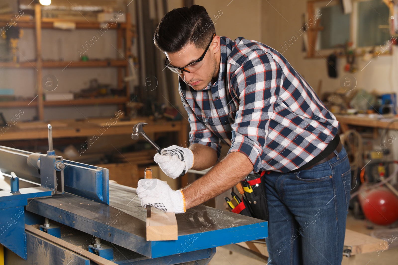 Photo of Professional carpenter working with wooden plank in workshop