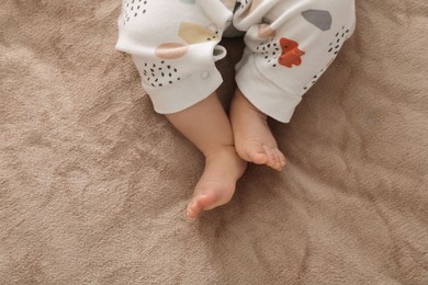 Photo of Little baby on brown blanket, top view