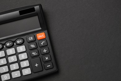 Calculator on black background, top view. Space for text