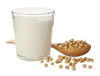 Photo of Glass of fresh soy milk and spoon with beans on white background