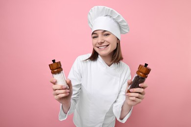 Professional chef with spices on pink background