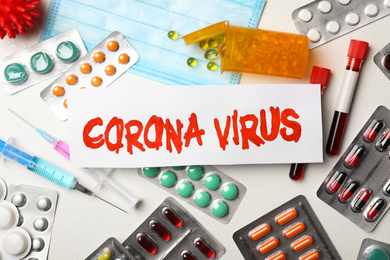 Photo of Flat lay composition with phrase CORONA VIRUS and medicines on white background