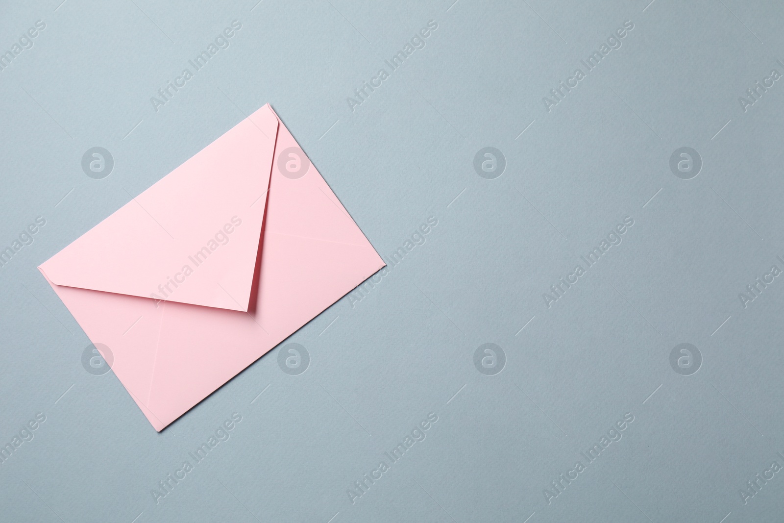 Photo of Letter envelope on grey background, top view. Space for text