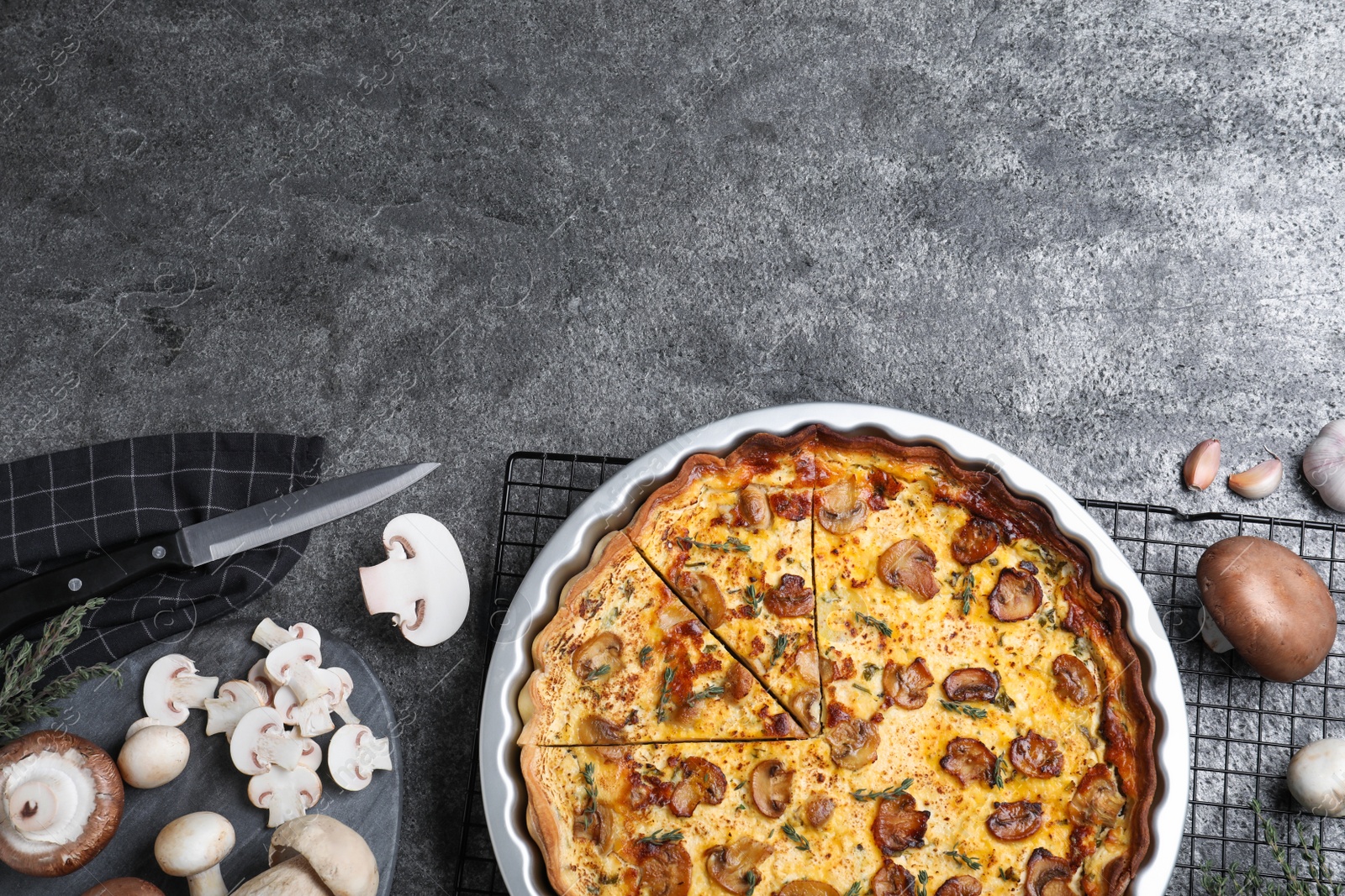 Photo of Delicious pie with mushrooms and cheese served on dark grey table, flat lay. Space for text