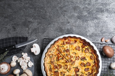 Delicious pie with mushrooms and cheese served on dark grey table, flat lay. Space for text