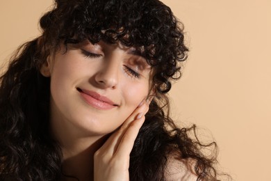 Portrait of beautiful young woman on beige background