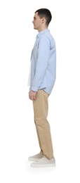 Young man in light blue shirt and beige pants on white background