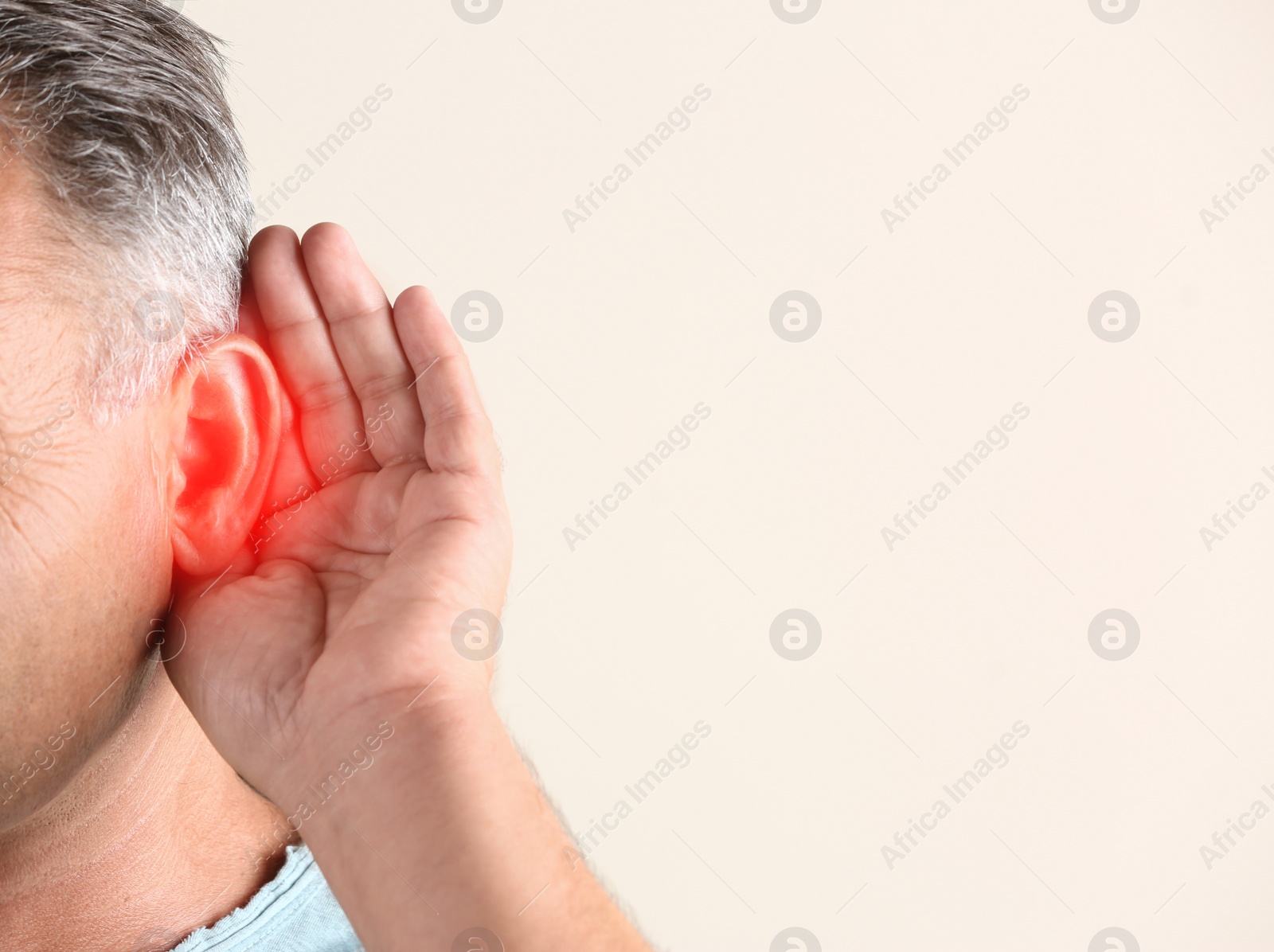 Image of Mature man suffering from earache on light background, closeup. Space for text