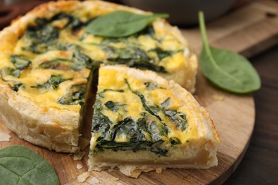 Photo of Delicious pie with spinach on wooden table, closeup