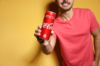 MYKOLAIV, UKRAINE - NOVEMBER 28, 2018: Young man with Coca-Cola can on color background, closeup. Space for text