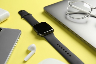 Photo of Composition with stylish smart watch on yellow background